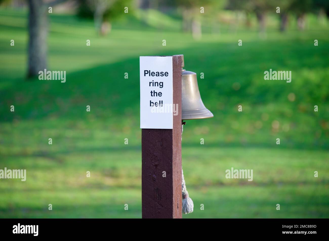 Ring the bell please sign on golf course Stock Photo