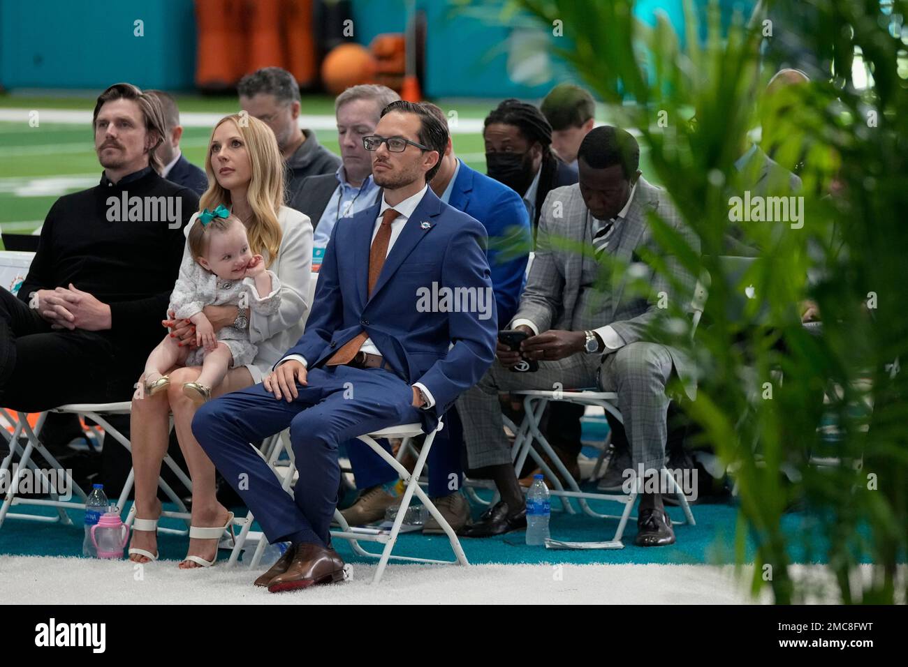 Miami Dolphins new head coach Mike McDaniel, center, sits beside his wife  Katie McDaniel and their daughter Ayla June, 16-months, at an introductory  press conference, Thursday, Feb. 10, 2022, in Miami Gardens,