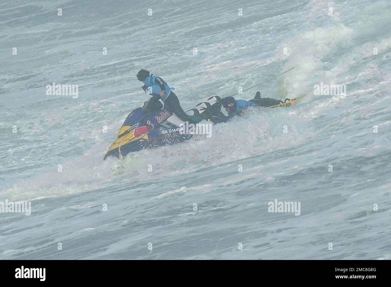 Surfer Justine Dupont from France is rescued by teammate Tony Laureano,  steering the jet ski, after breaking her foot riding a wave during the  Nazare Tow Challenge big wave surfing competition at
