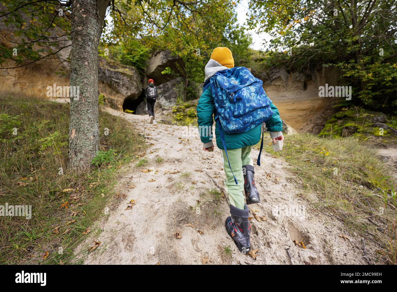 Two brothers wear backpack explore limestone stone caves at mountain in