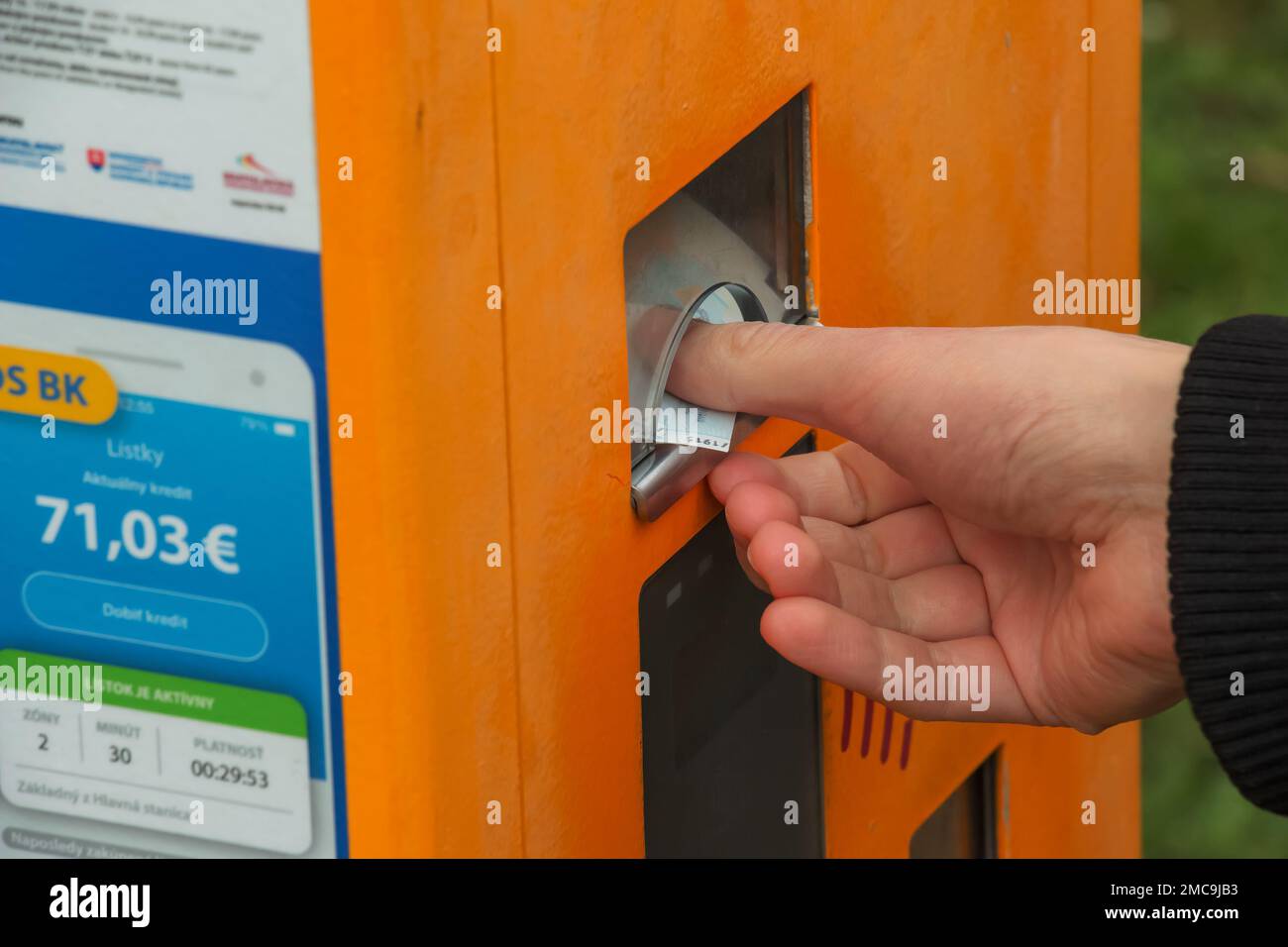 A woman's hand buys a ticket in a ticket machine. Stock Photo