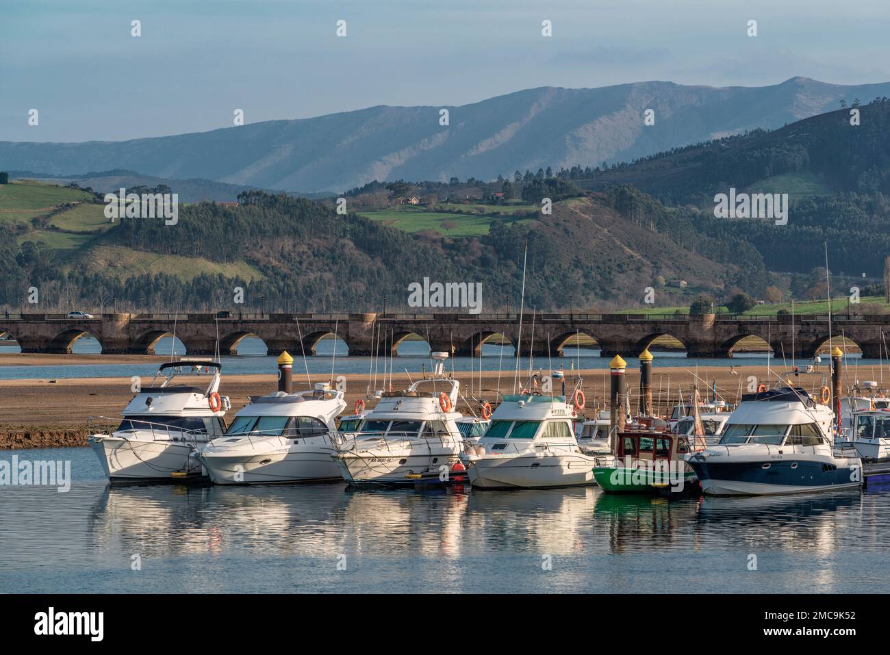 Sports boats and recreational yachts with the Maza bridge in the background in San Vicente de la Barquera, Cantabria, Spain Stock Photo