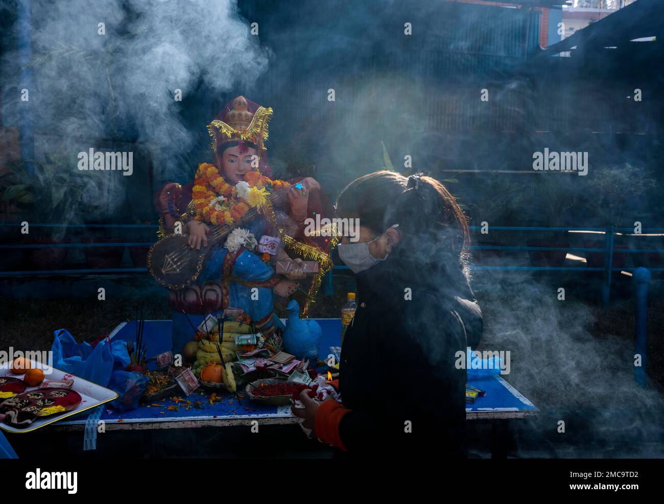 A Nepalese student offers prayers before a statue of Hindu goddess ...