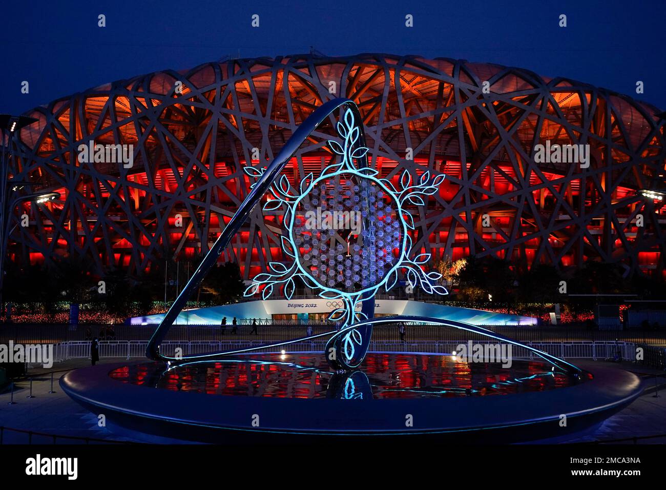 The Olympic flame burning in the center of the snowflakeshaped