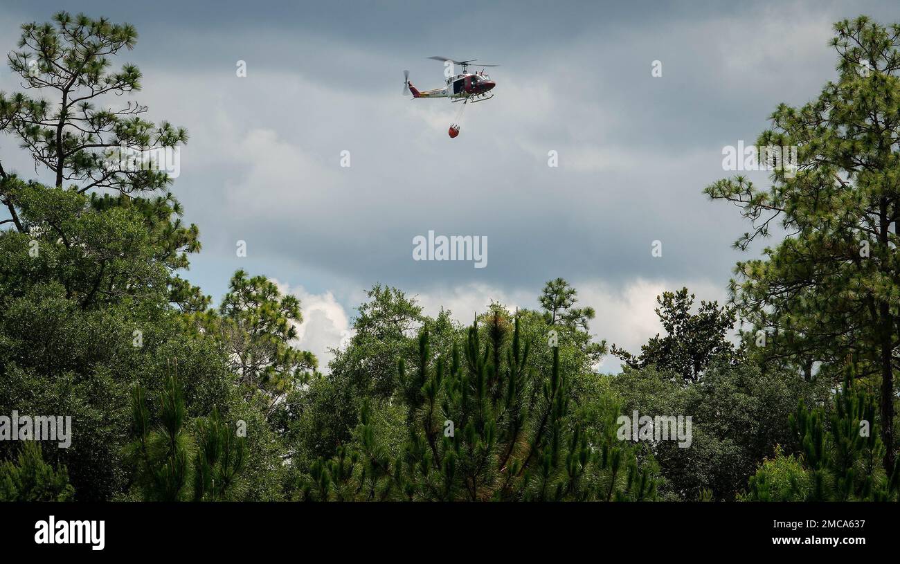 A 413th Flight Test Squadron UH1 Huey flies toward Anderson Pond