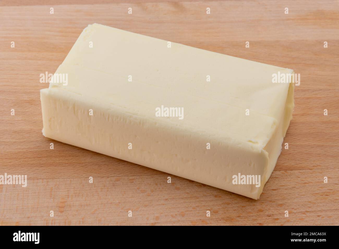 Block of butter on wooden cutting board Stock Photo