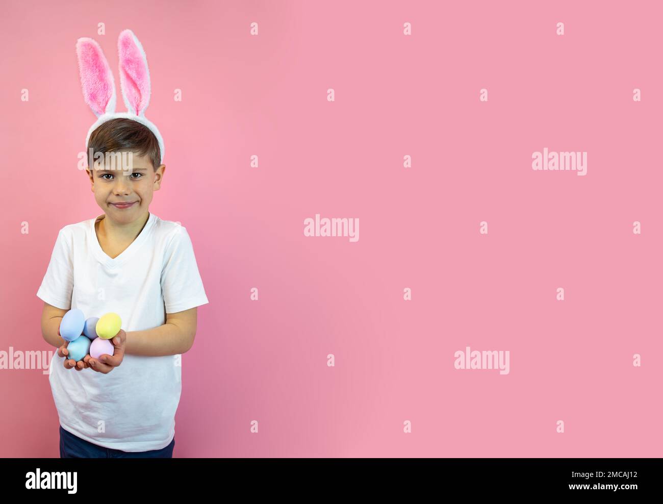 Wide Easter banner.A boy in the ears of a hare holds eggs in his hands. Stock Photo