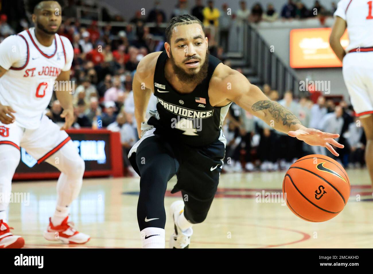 Providence guard Jared Bynum (4) goes for a loose ball against St. John