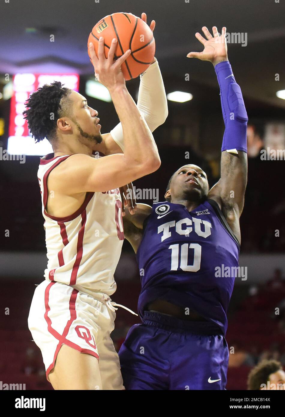 Oklahoma guard Jordan Goldwire , left, goes up for a shot over TCU
