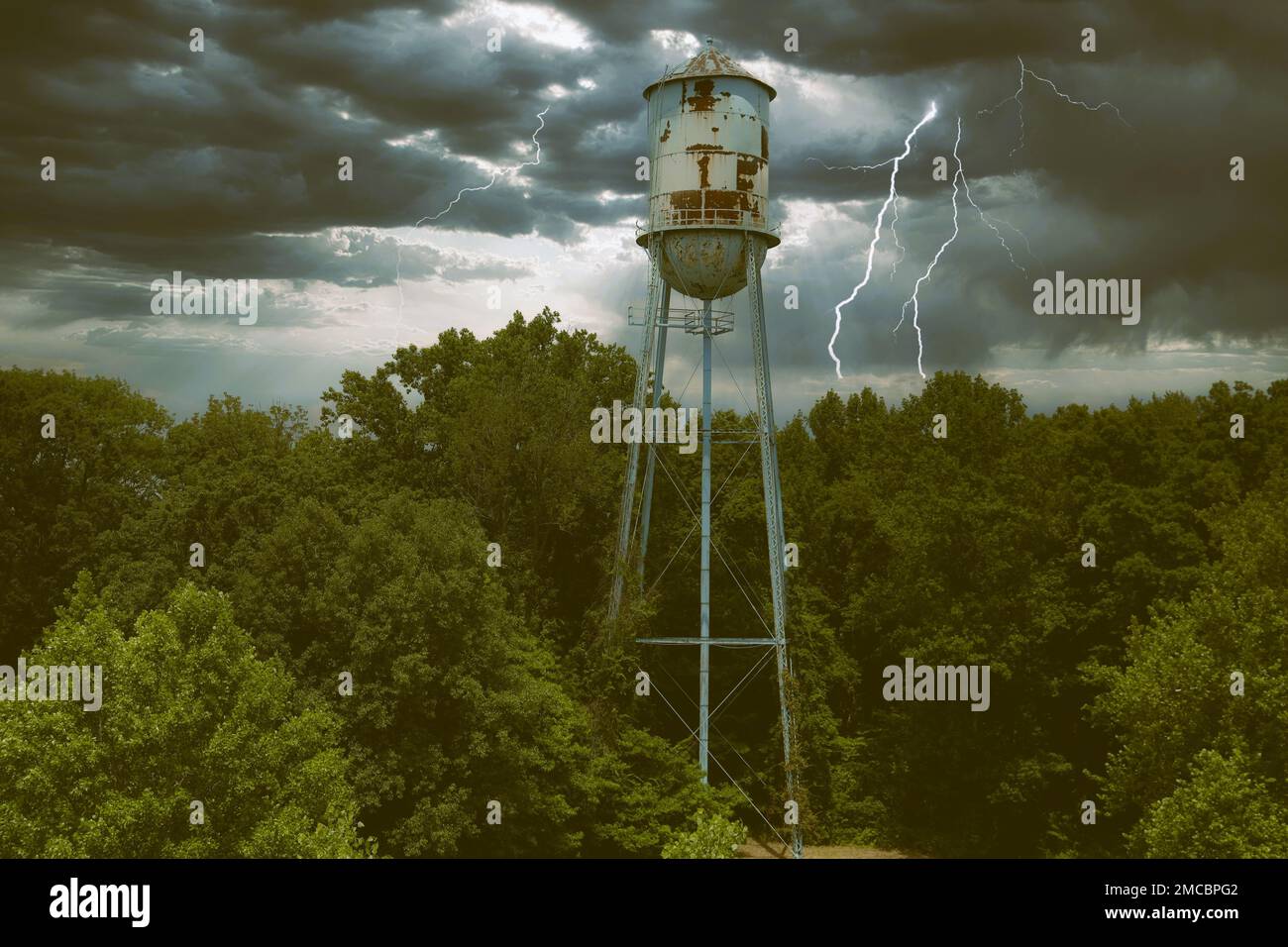 An aerial view of an old water tower with a cloudy sky and stormy