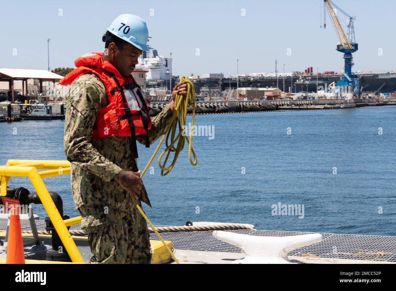 220629-N-KD380-2147   SAN DIEGO (June 29, 2022) – Aviation Boatswain’s Mate (Fuels) Airman Justin Thomas-Thornton handles line as the San Antonio-class amphibious transport dock ship USS Portland (LPD 27) pier-side onboard Naval Air Station North Island to participate in Rim of the Pacific (RIMPAC) 2022 in Southern California. Twenty-six nations, 38 ships, four submarines, more than 170 aircraft and 25,000 personnel are participating in RIMPAC from June 29 to Aug. 4 in and around the Hawaiian Islands and Southern California. The world’s largest international maritime exercise, RIMPAC provides Stock Photo