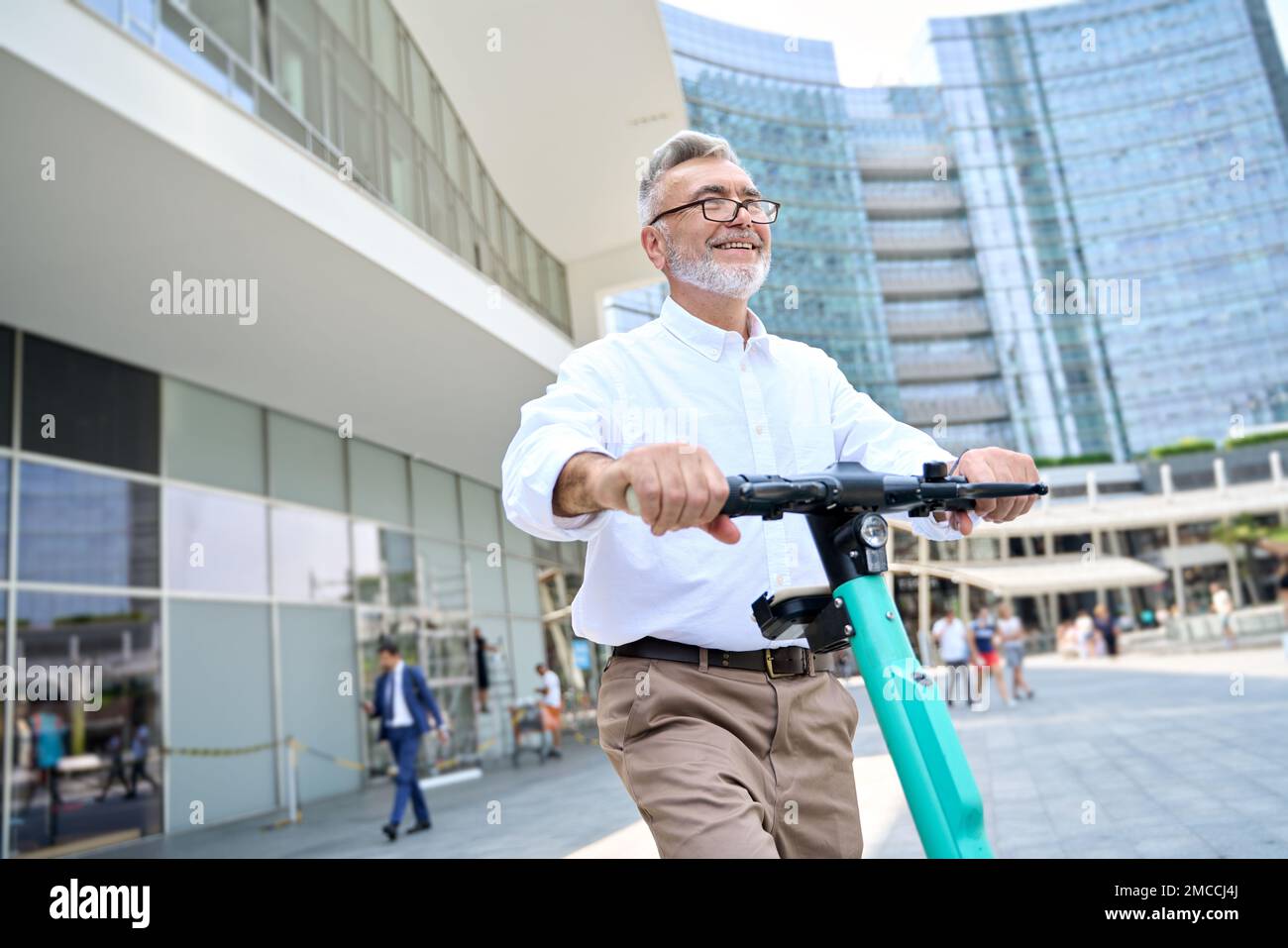 Happy older man using mobile app for bike rental renting bike in city park. Stock Photo