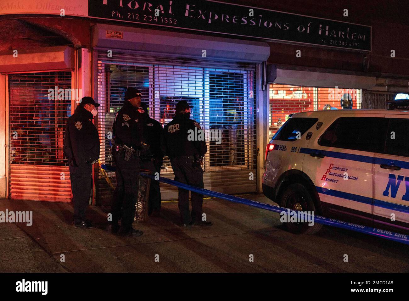 NYPD officers investigate the scene of a shooting in Harlem on Friday ...