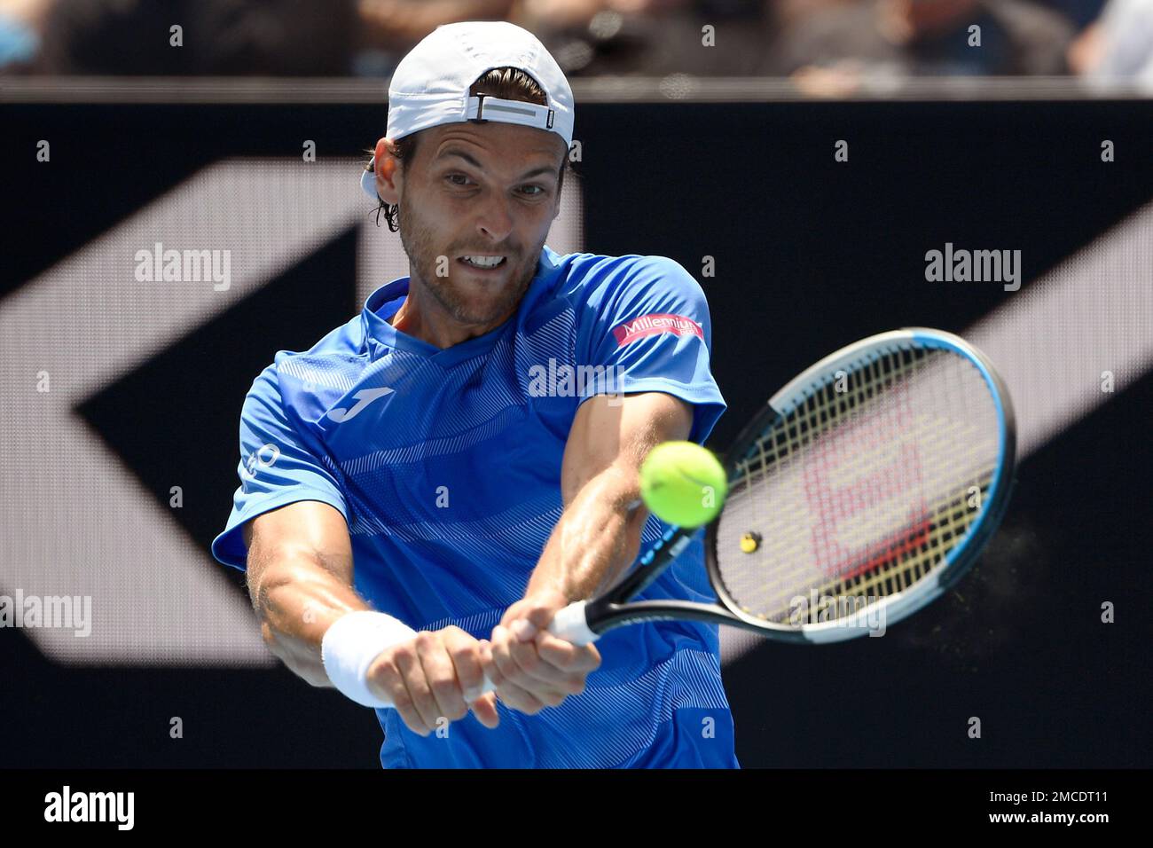Joao Sousa of Portugal plays a backhand return to Jannik Sinner of Italy  during their first round match at the Australian Open tennis championships  in Melbourne, Australia, Tuesday, Jan. 18, 2022. (AP