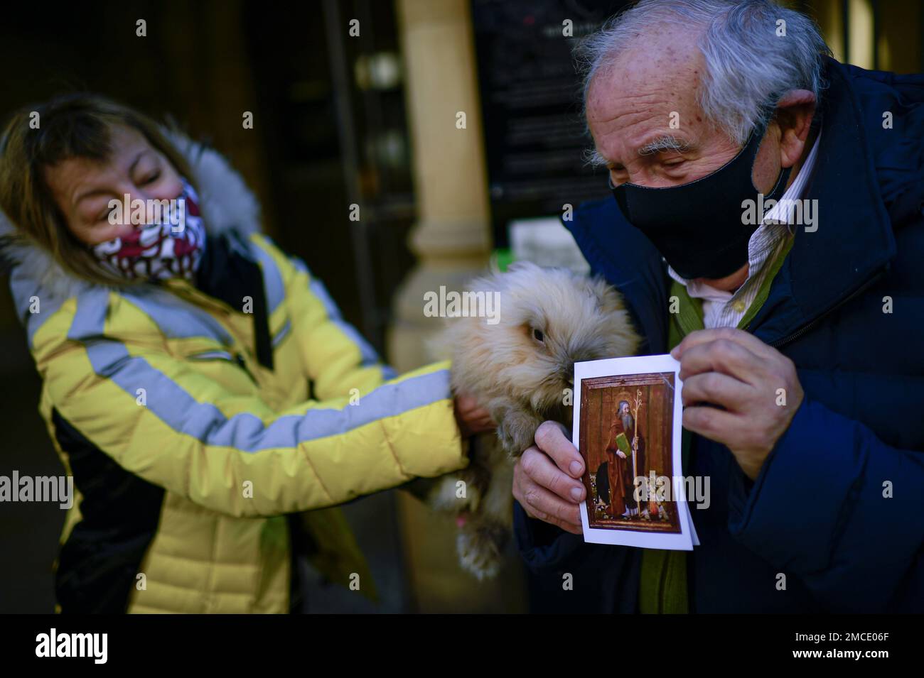 82 year old Fernando Hipolito holds his pet rabbit and a religious card ...