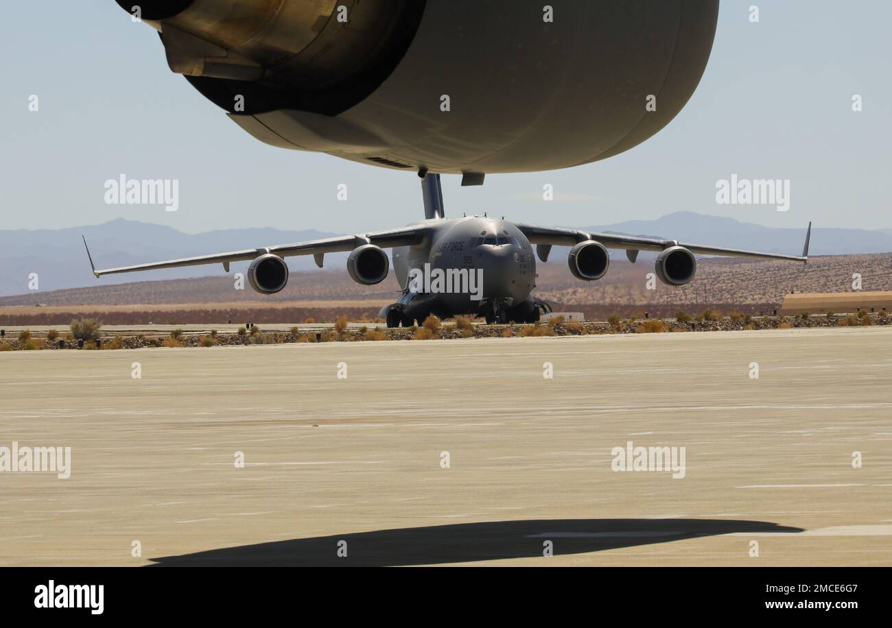 A U.S Air Force C-17 Globemaster III aircraft with the 21st Airlift Squadron, 60th Air Mobility Wing (AMW) lands at the Strategic Expeditionary Landing Field for joint exercise Patriot Hook at Marine Corps Air Ground Combat Center, Twentynine Palms, California, June 29, 2022. Air Force 60th AMW delivered Marine Corps UH-1Y Venom helicopters and AH-1Z Viper helicopters to conduct strike missions, testing Marine Light Attack Helicopter Squadron 267 (HMLA-267) rapid deployment capabilities. Stock Photo