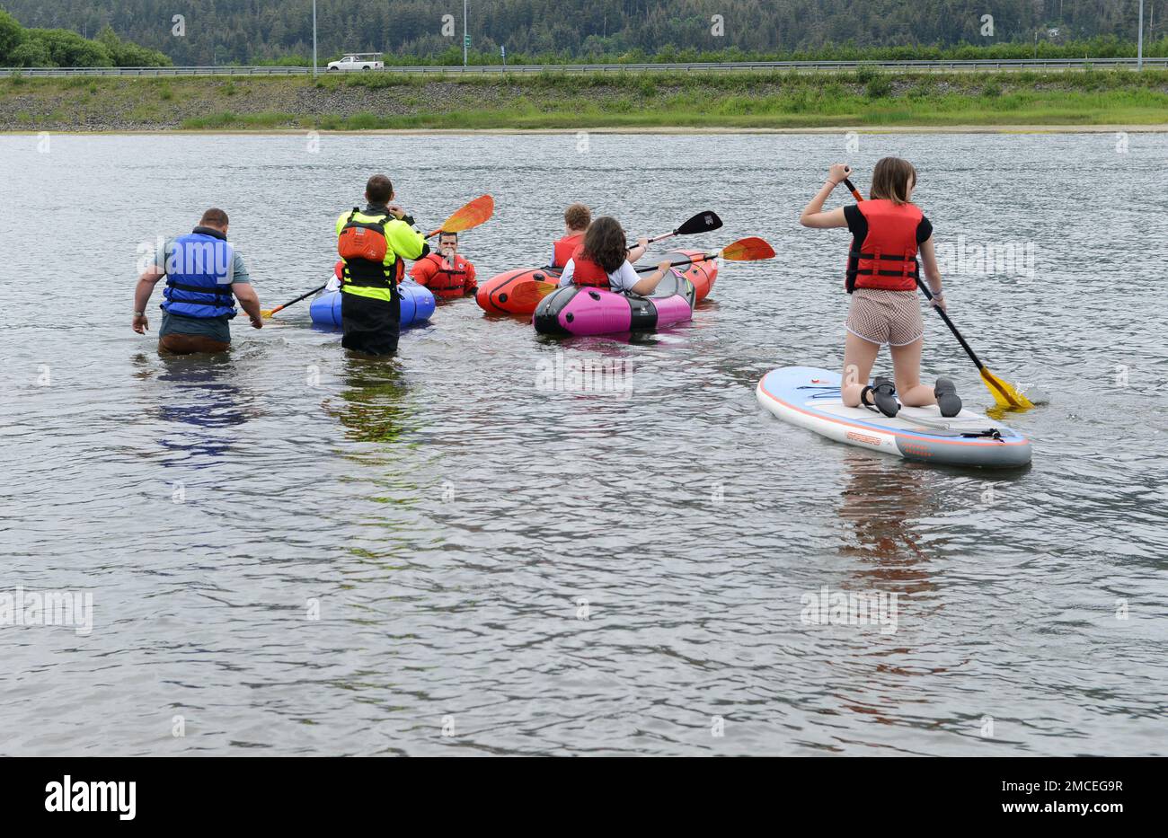 Coast Guard personnel teaching children how to use paddle craft at Twin