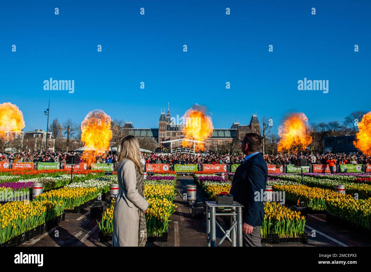 Olympic skating champion, Irene Schouten (left), and President of the organization 'Tulpen promotie Nederland', Arjan Smit (right) are seen watching the fire spectacle during the inauguration. Each year on the 3rd Saturday of January, the National Tulip Day is celebrated in Amsterdam. Dutch tulip growers built a huge picking garden with more than 200,000 colorful tulips at the Museumplein in Amsterdam. Visitors are allowed to pick tulips for free. The event was opened by Olympic skating champion, Irene Schouten. Prior to the opening, she christened a new tulip: Tulipa 'Dutch Pearl' as a refere Stock Photo