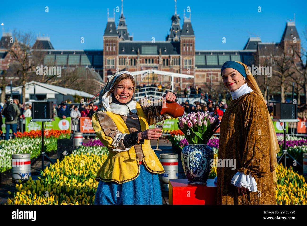 Two women dressing like two characters from the paints of Johannes Vermeer paintings are seen posing for the media. Each year on the 3rd Saturday of January, the National Tulip Day is celebrated in Amsterdam. Dutch tulip growers built a huge picking garden with more than 200,000 colorful tulips at the Museumplein in Amsterdam. Visitors are allowed to pick tulips for free. The event was opened by Olympic skating champion, Irene Schouten. Prior to the opening, she christened a new tulip: Tulipa 'Dutch Pearl' as a reference to the world - famous painting 'The girl with a pearl earring' by Johanne Stock Photo