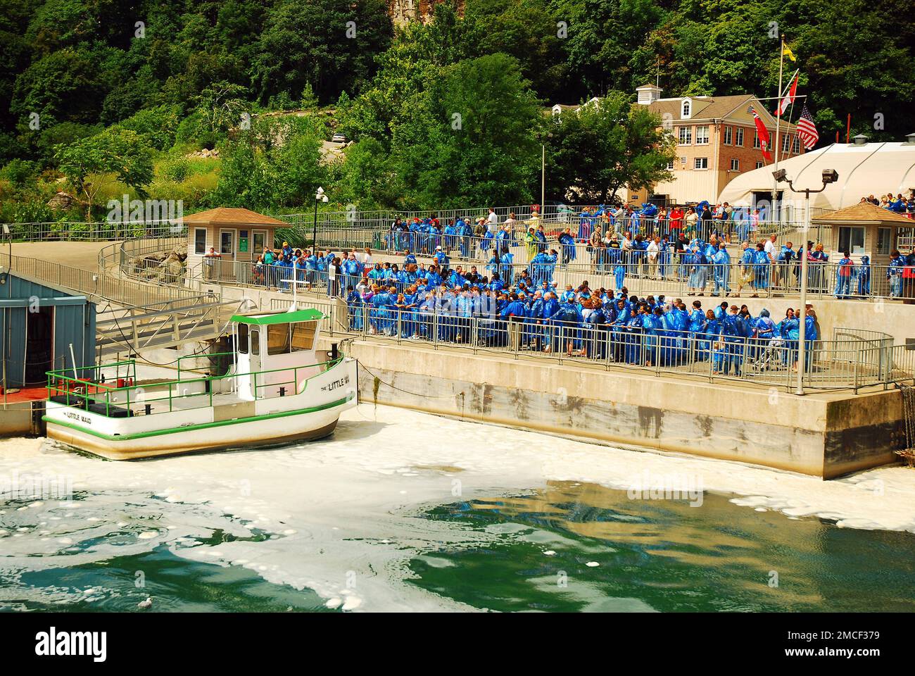 A Crowd of tourists Gathers for the Maid of the Mist tour boat ride while wearing blue ponchos in Niagara Falls, Canada Stock Photo