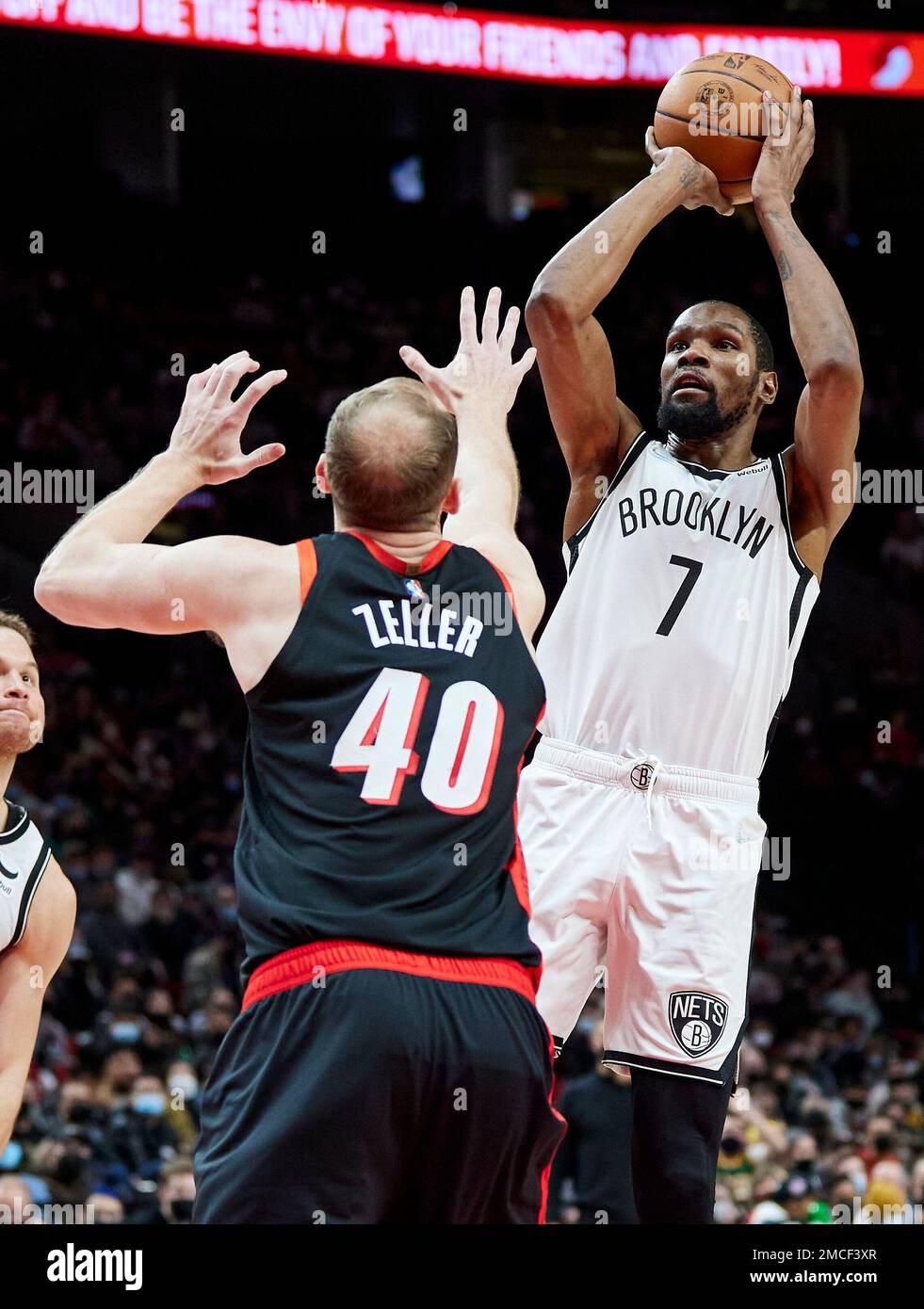 Brooklyn Nets forward Kevin Durant, right, shoots over Portland Trail  Blazers center Cody Zeller during the second half of an NBA basketball game  in Portland, Ore., Monday, Jan. 10, 2022. (AP Photo/Craig