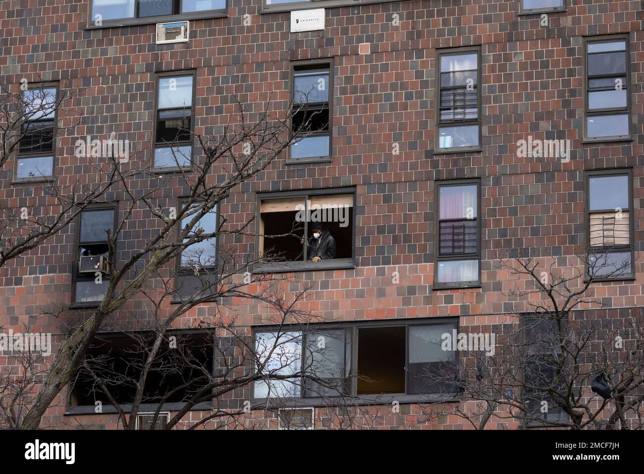 A person works to cover the window frame in the apartment building ...
