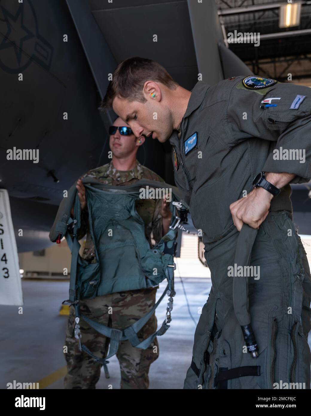 Maj, John McFarlin, Florida Air National Guard's 125th Fighter Wing, Detachment 1, F-15C pilot, finishes putting on the bottom half of his g-suit while Staff Sgt. Jackson Carroll, Florida Air National Guard's 125th Fighter Wing, Detachment 1, crew chief, stands ready with the top half of the g-suit at Homestead Air Reserve Base, Florida in support of North American Aerospace Defense Command's (NORAD) Operation Noble Defender (OND), June 30, 2022. As a part of OND, a routine operation, the Continental U.S. NORAD Region (CONR) coordinated and conducted joint operations with the U.S. Navy while c Stock Photo