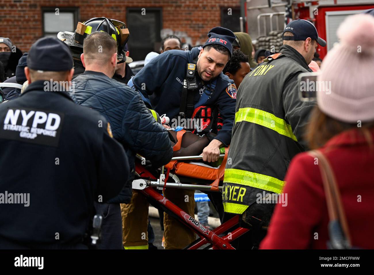 Emergency personnel bring a fire victim to an ambulance during a high