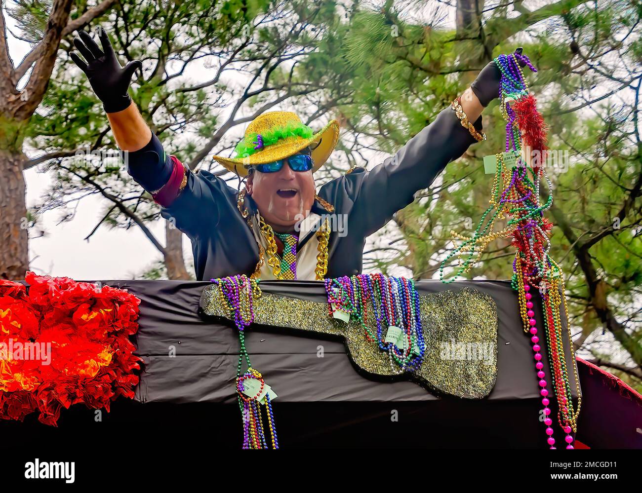 A man throws Mardi Gras beads during the Krewe de la Dauphine Mardi Gras parade, Jan. 21, 2023, in Dauphin Island, Alabama. Stock Photo