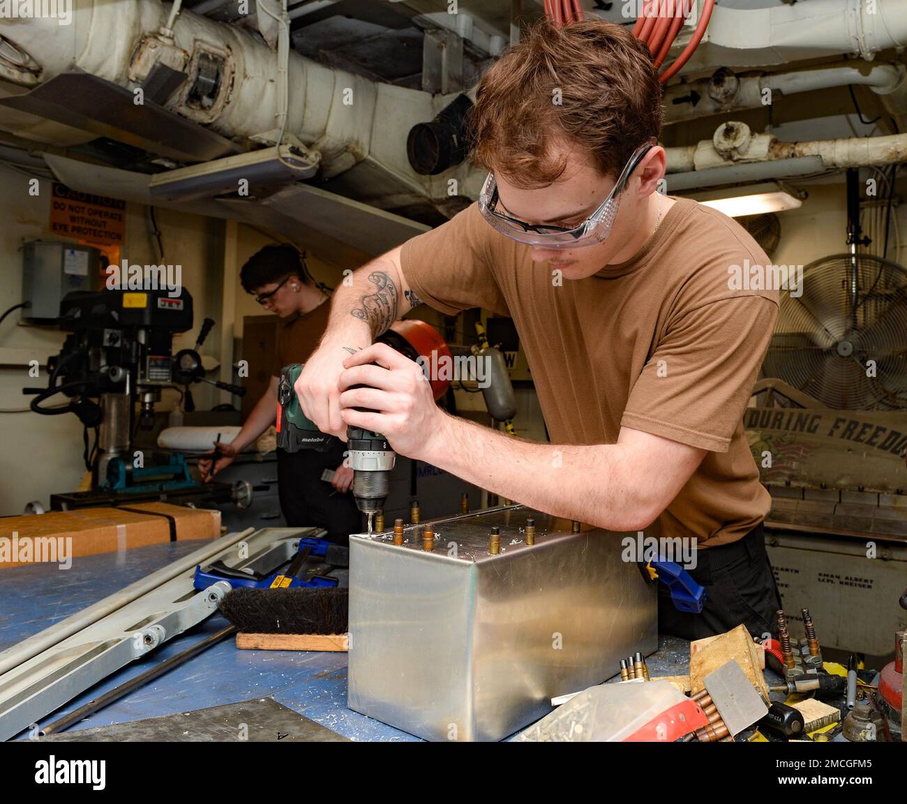 220701-N-FB730-1106 ADRIATIC SEA (July 1, 2022) Aviation Structural Mechanic Airman Steven Knight, from CHarlotte, North Carolina, drills a hole in a trash can cover for an on-the-job qualification project in the jet shop aboard the USS Harry S. Truman (CVN 75), July 1, 2022. The Harry S. Truman Carrier Strike Group is on a scheduled deployment in the U.S. Naval Forces Europe area of operations, employed by U.S. Sixth Fleet to defend U.S., allied and partner interests. Stock Photo