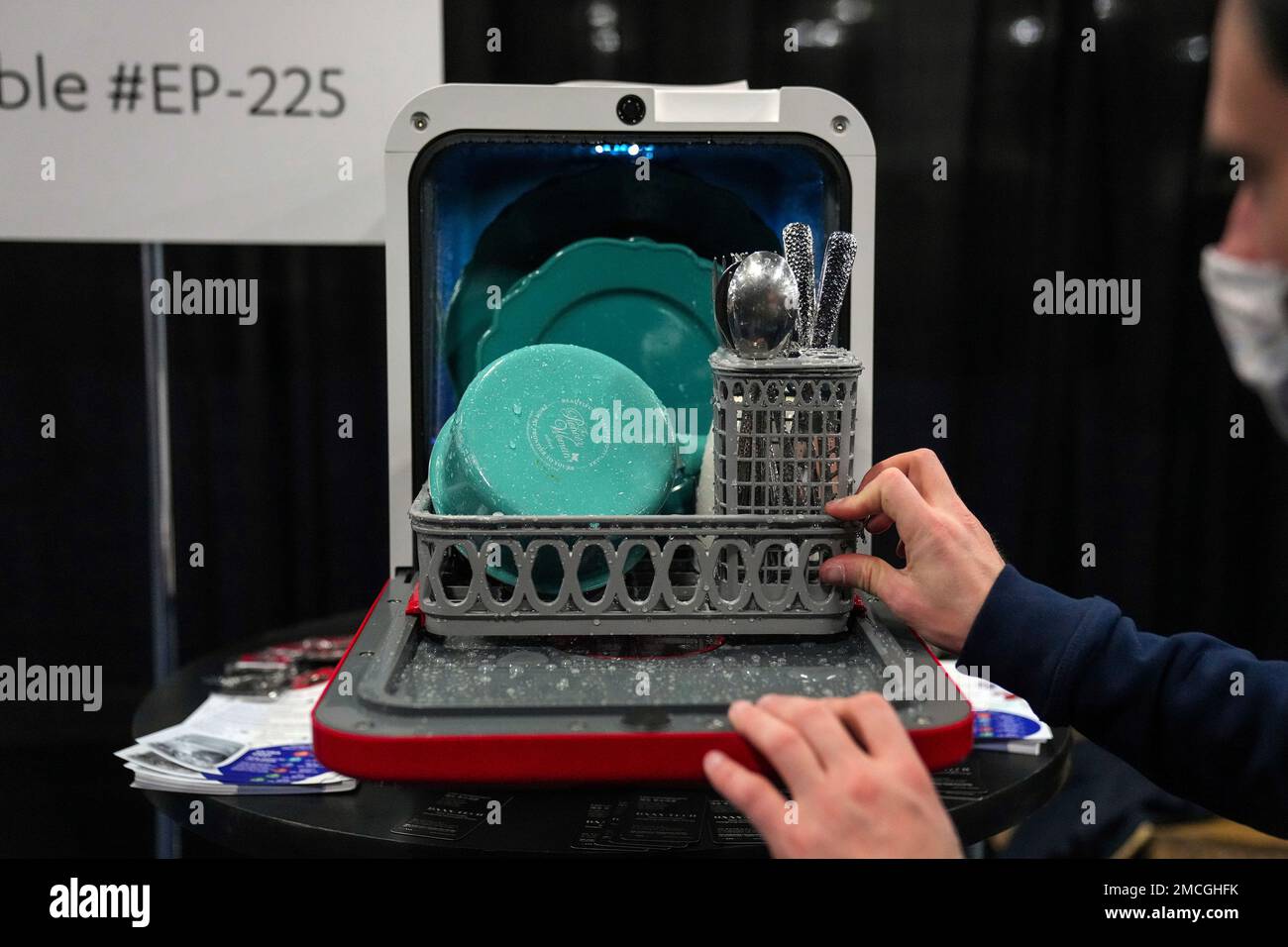 A man demonstrates the Bob dishwasher at the Daan Technologies booth during CES Unveiled ahead