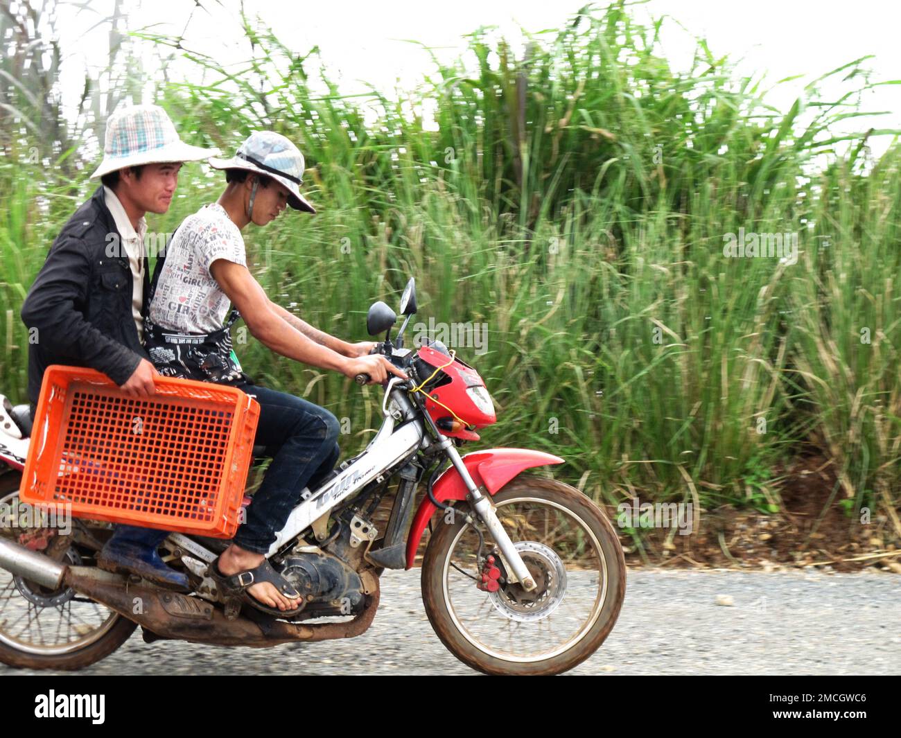 Man hmong tribal people and men thai karen ethnic riding local old motorcycle on street and traffic road on Mon Jam village mountain hill at Chiangmai Stock Photo