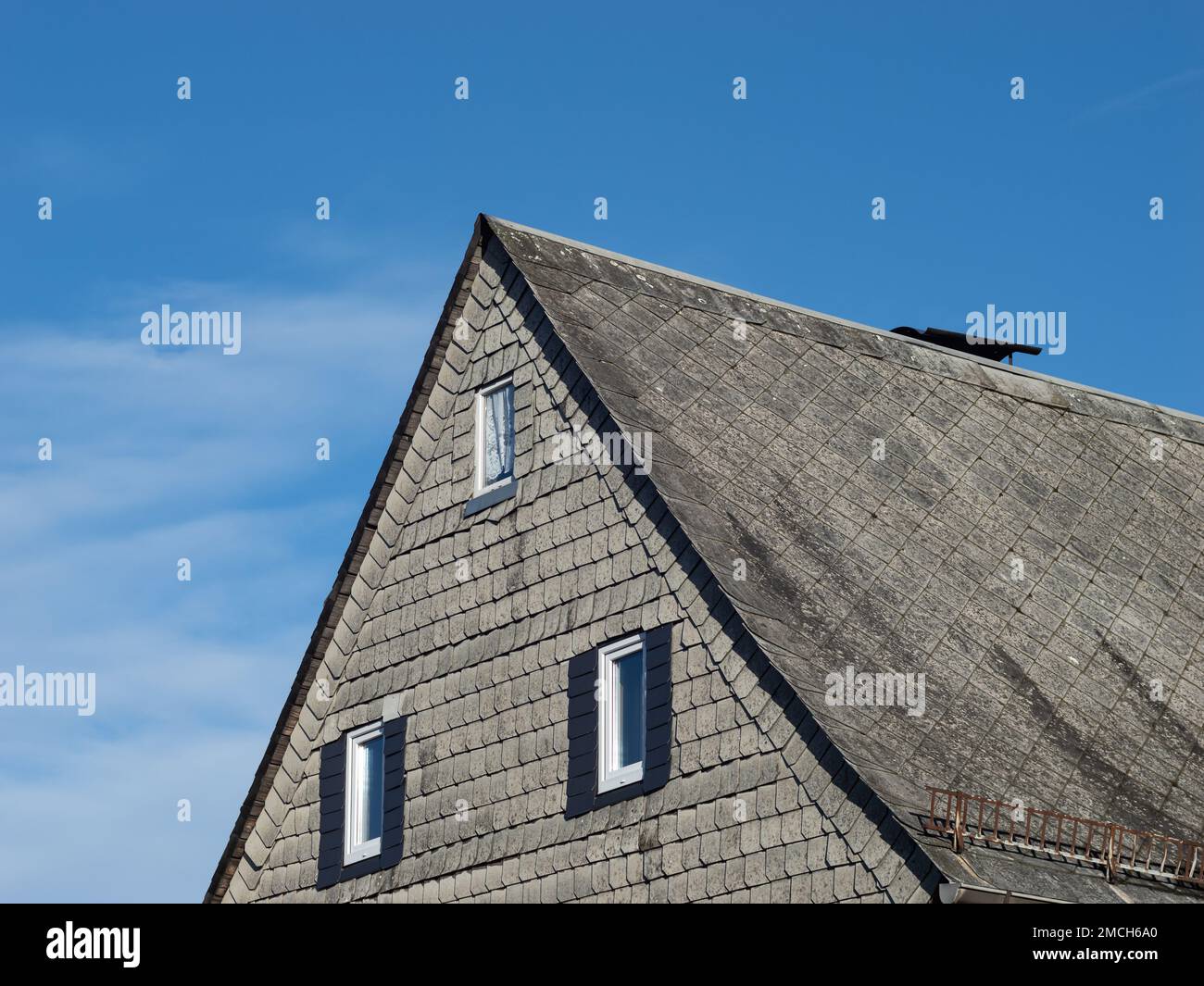 Asbestos on an exterior wall and on the rooftop of a residential