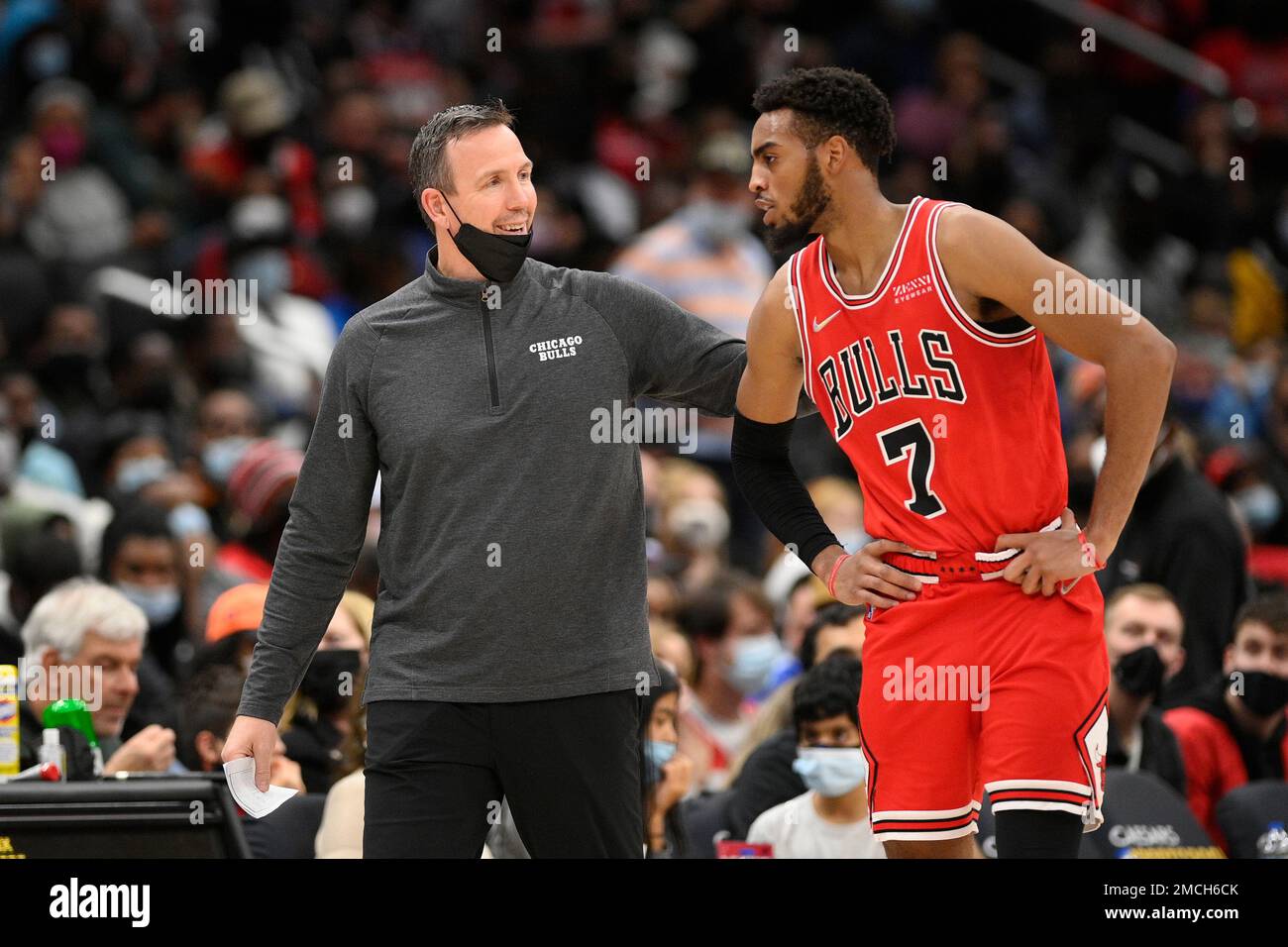 Chicago Bulls acting head coach Chris Fleming, left, talks with forward  Troy Brown Jr. (7) during the first half of an NBA basketball game against  the Washington Wizards, Saturday, Jan. 1, 2022,