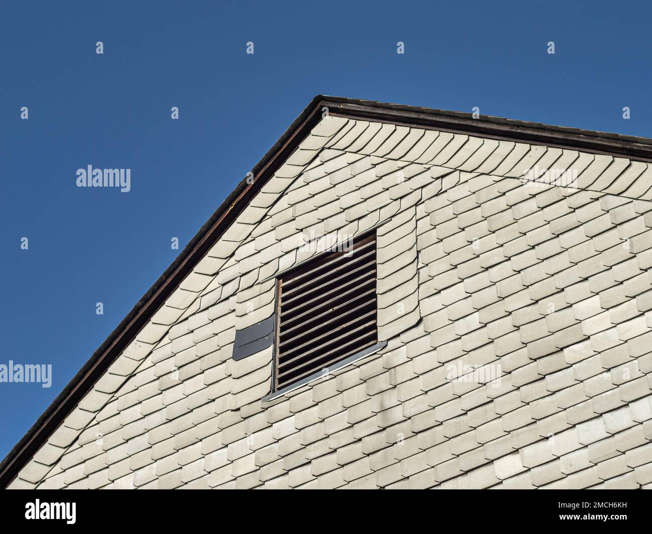 Asbestos facade of a residential building in East Germany. Grey fibrous