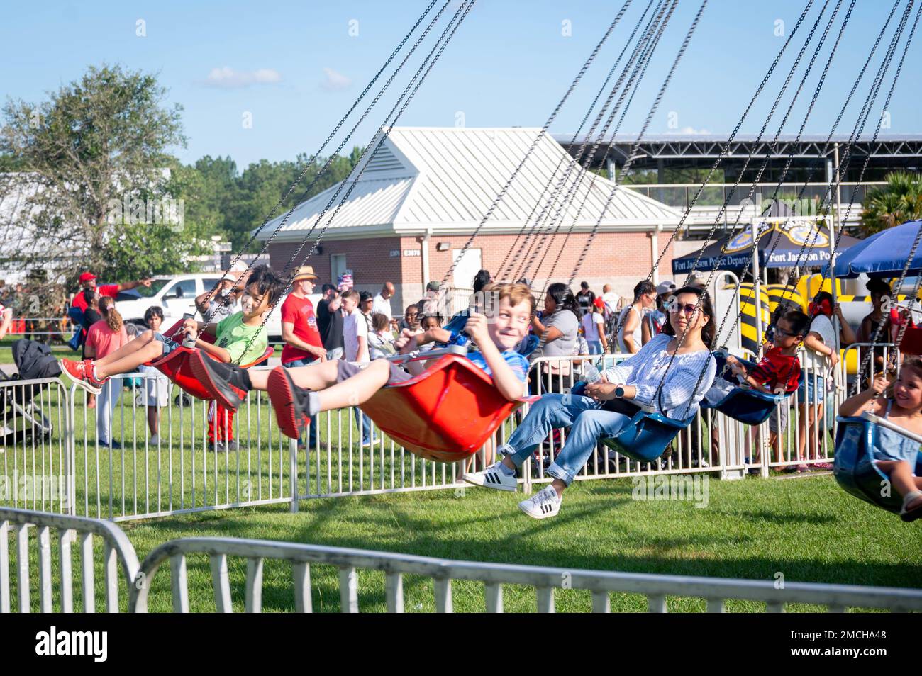 Children and their parents enjoy a swing ride in the Kids Zone July 2