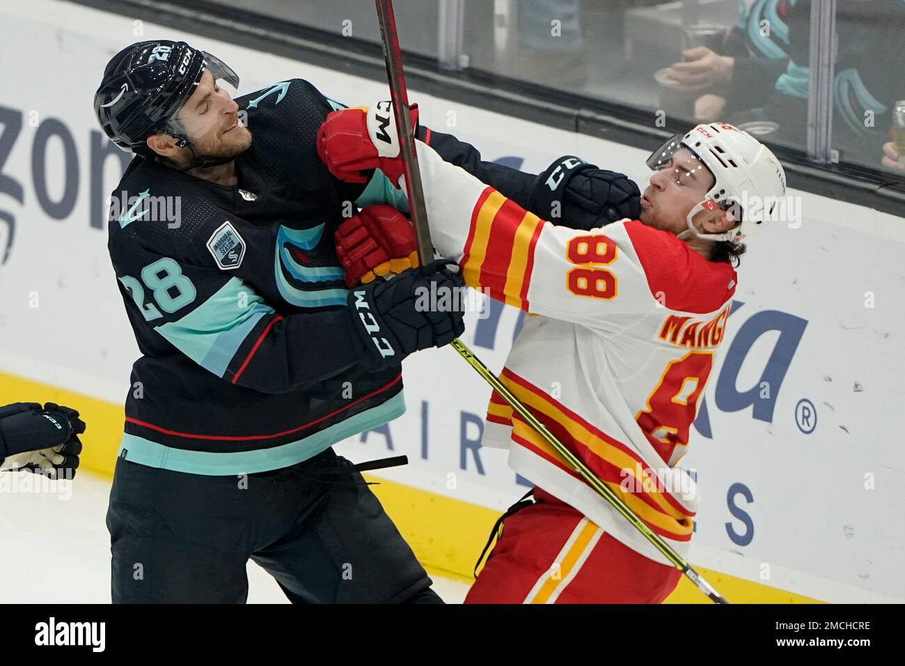 Seattle Kraken defenseman Carson Soucy (28) fights with Calgary Flames left wing Andrew Mangiapane (88) during