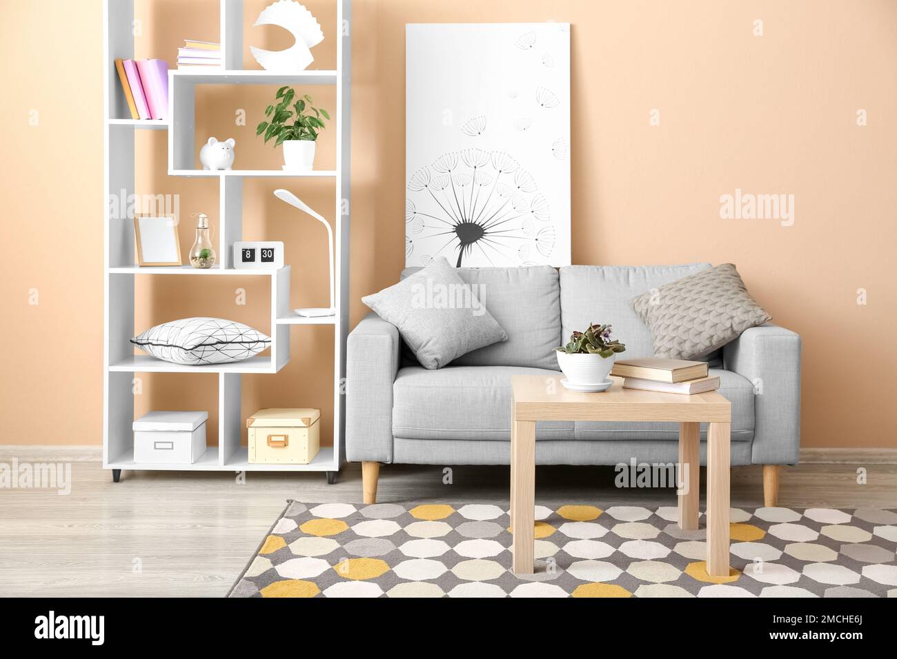 Interior of stylish living room with grey sofa, table and shelving unit ...
