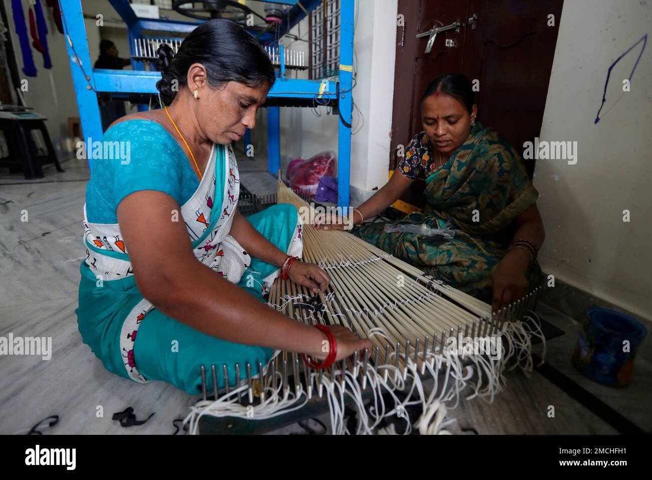 Indian weavers prepare silk yarn for dyeing at a small scale handloom