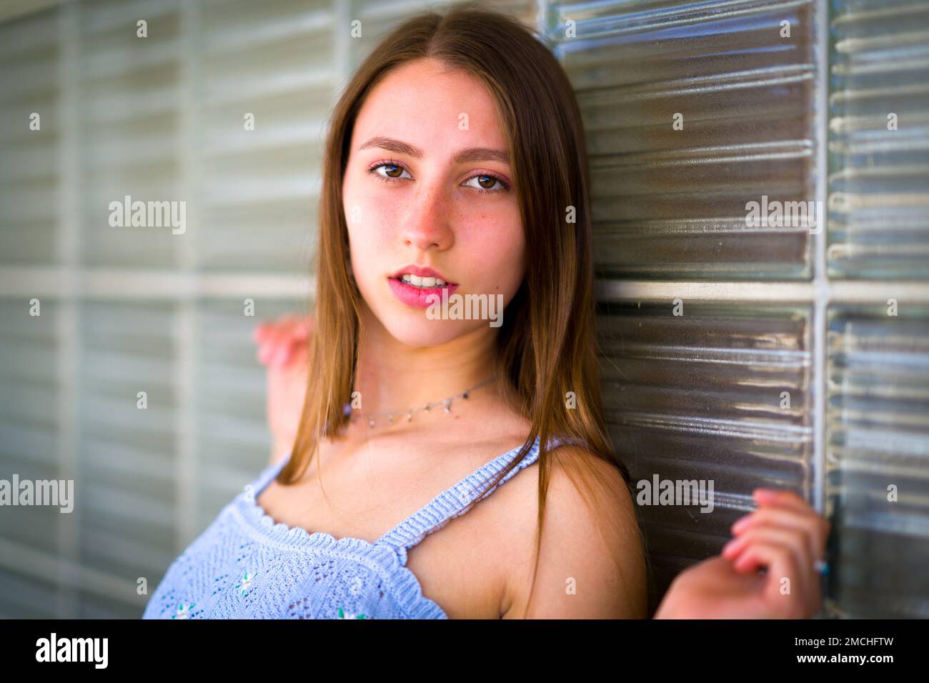 Close up Portrait of Teenage Girl Leaning Against Art Deco Glass Brick