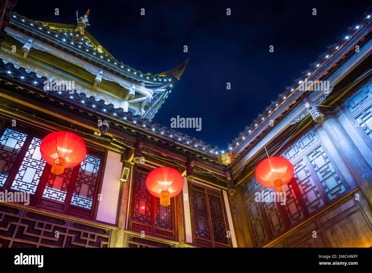 Red Chinese lanterns hanging on a traditional Chinese building at night Stock Photo