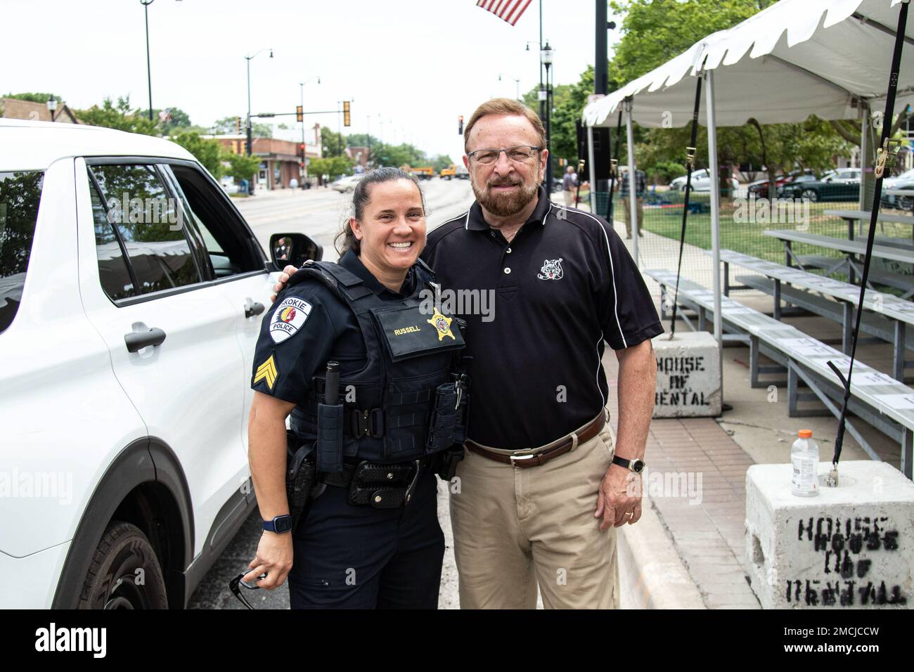 Skokie (Illinois) Police Sgt. Melissa Russell stands with Wayne Messmer, the celebrated National Anthem soloist for the National Hockey League's Chicago Blackhawks before the Skokie Independence Day Parade on July 4 was cancelled due to safety concerns after an active shooter incident in Highland Park, Illinois, about 13 miles away. The Illinois National Guard was supporting the Skokie parade with the 144th Army Band and vehicles from the 1970th Quartermaster Co. Three local Army veterans, Staff Sgt. Paul Plotnik, Mr. Gerald Jaffe, and Illinois Army National Guard Master Sgt. Hank Gould were s Stock Photo