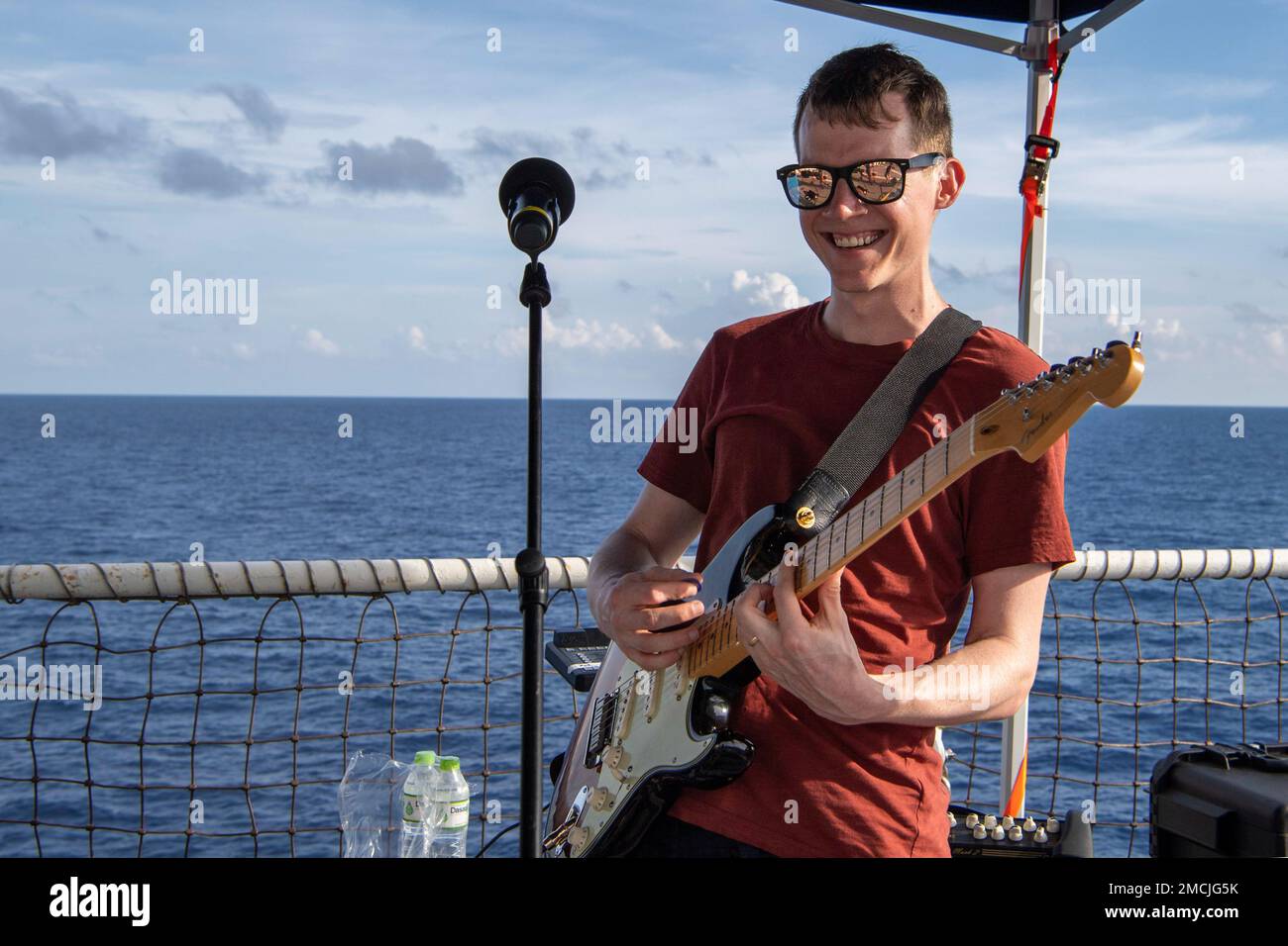 SOUTH CHINA SEA (July 5, 2022) – Able Body Seaman Philip Edey, a musician in the Royal Australian Navy, performs during a Fourth of July Celebration aboard Military Sealift Command hospital ship USNS Mercy (T-AH 19) while underway for Pacific Partnership 2022. Now in its 17th year, Pacific Partnership is the largest annual multinational humanitarian assistance and disaster relief preparedness mission conducted in the Indo-Pacific. Stock Photo