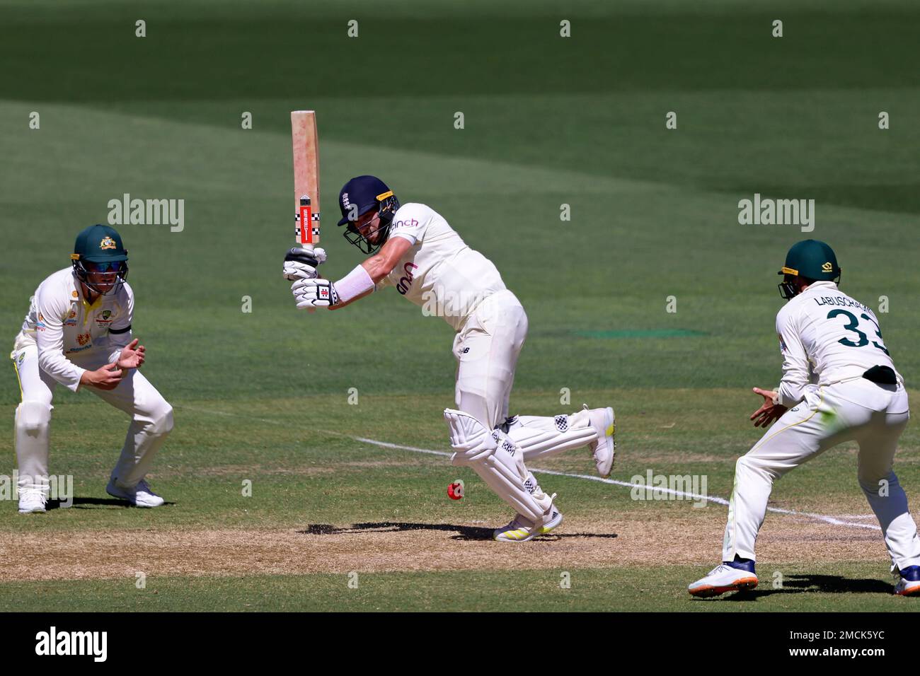 England's Chris Woakes, center, bats as Australia's Marcus Harris, left