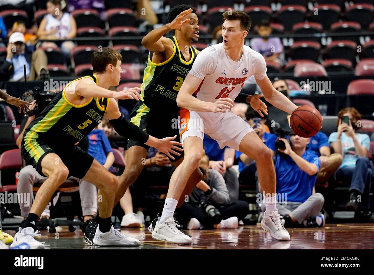 Florida forward Colin Castleton (12) drives to the basket as South Florida  forward Jake Boggs (5) and forward DJ Patrick (3) defend during the second  half of the NCAA college Orange Bowl
