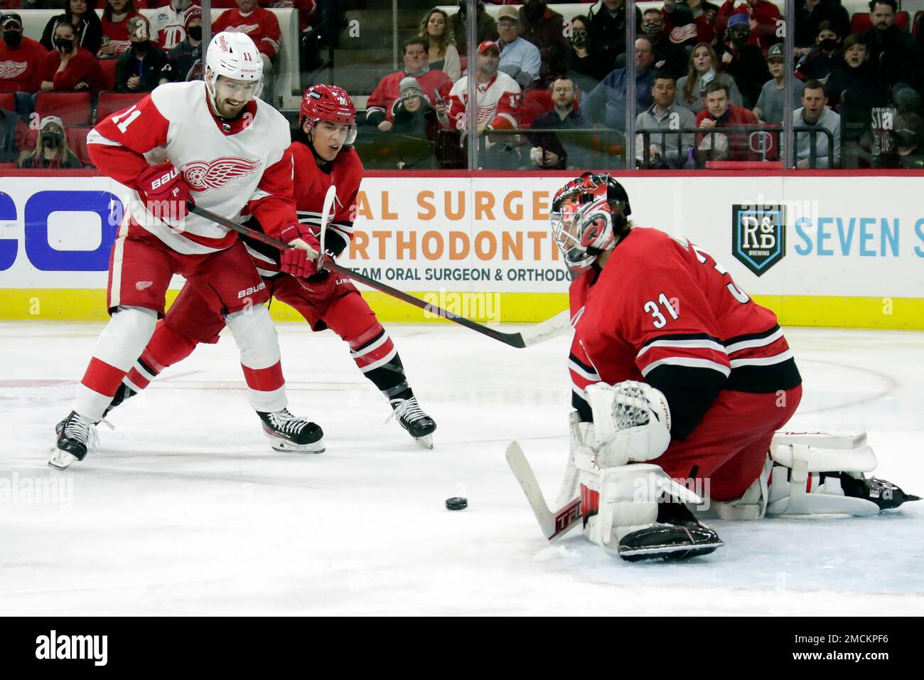 Detroit Red Wings right wing Filip Zadina (11) is defended by Carolina  Hurricanes defenseman Ethan Bear, center, and goaltender Frederik Andersen  (31) as he tries to score during an NHL hockey game