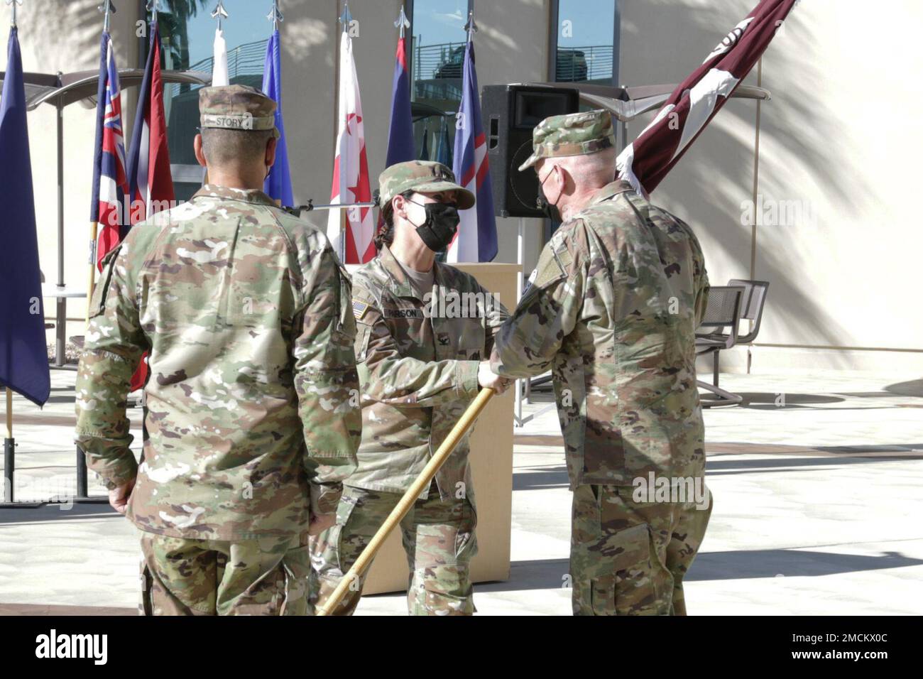 Col. Nancy Parson (center), outgoing commander, passes the Weed Army Community Hospital colors to Brig. Gen. E. Darrin Cox, commanding general of Regional Health Command – Central, signifying the relinquishment of command of Weed ACH July 6, during a change of command ceremony at Weed ACH on Fort Irwin, Calif. (Photo by Kimberly Hackbarth/ Fort Irwin Public Affairs Office) Stock Photo