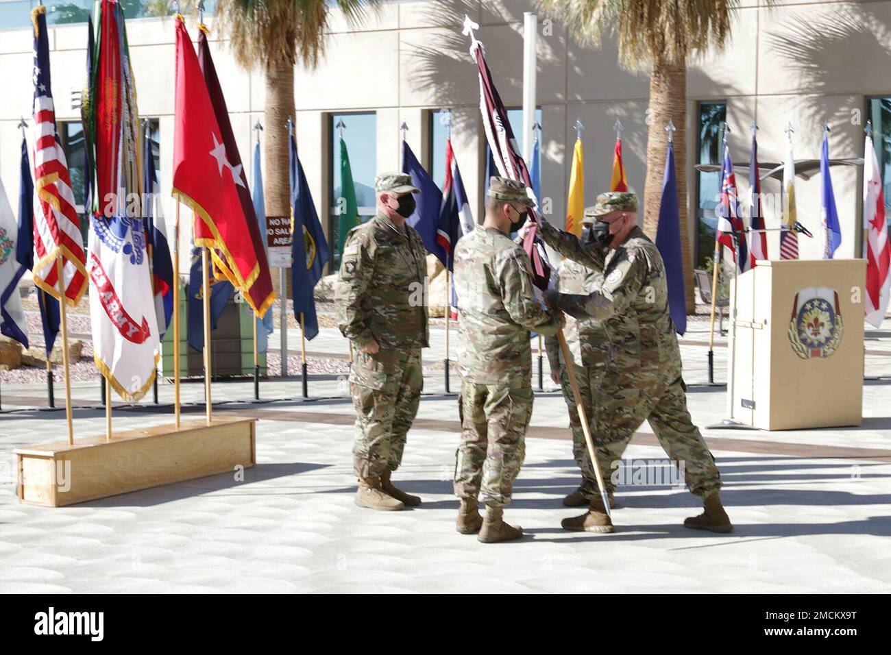 Col. Michael Story (center), incoming commander, receives the Weed Army Community Hospital colors from Brig. Gen. E. Darrin Cox, commanding general of Regional Health Command – Central, July 6, during a change of command ceremony at Weed ACH on Fort Irwin, Calif. (Photo by Kimberly Hackbarth/ Fort Irwin Public Affairs Office) Stock Photo