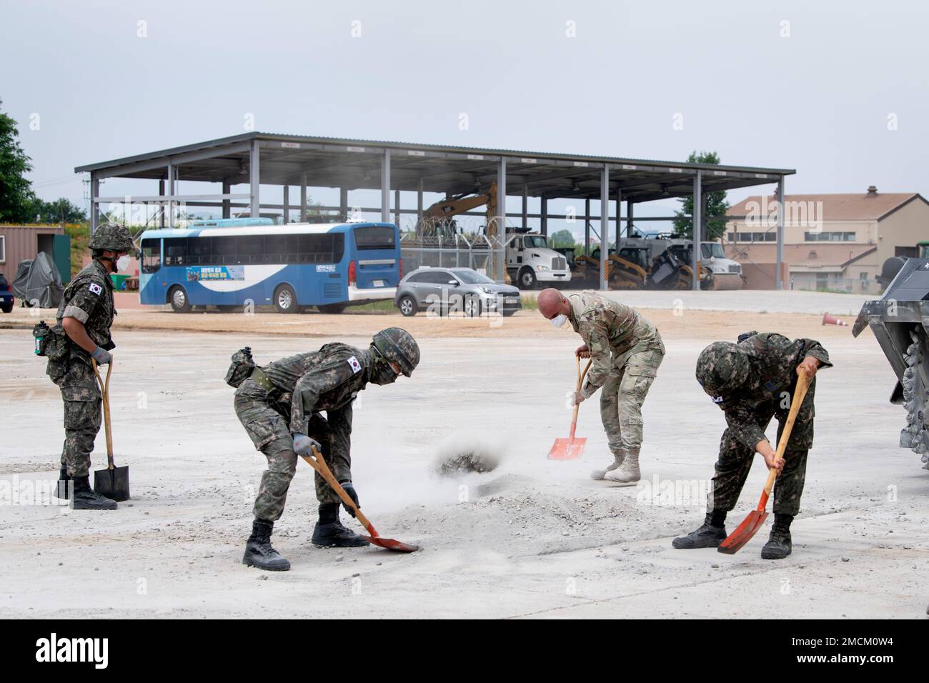 Senior Airman Ernesto Silio Cabrera, 35th Civil Engineer Squadron, water and fuels system maintenance technician from Misawa Air Base, Japan, and members of the Republic of Korea Air Force (ROKAF), shovel cement debris while conducting a runway repair training as part of a bilateral training scenario at Suwon Air Base, Republic of Korea, July 6, 2022. The members of the 35th CES traveled to Suwon Air Base to conduct bilateral training with the members of the Republic of Korea Air Force in order to enhance ROKAF-U.S. Air Force interoperability and increase readiness. Stock Photo