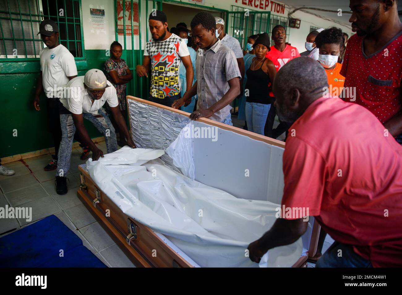 People place a woman in a coffin at Justinien University Hospital where